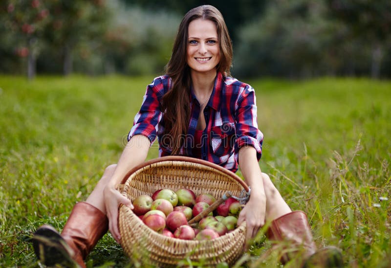 Beautiful woman sitting near a basket of apples royalty free stock images Beautiful woman sitting near a basket of apples royalty free stock images