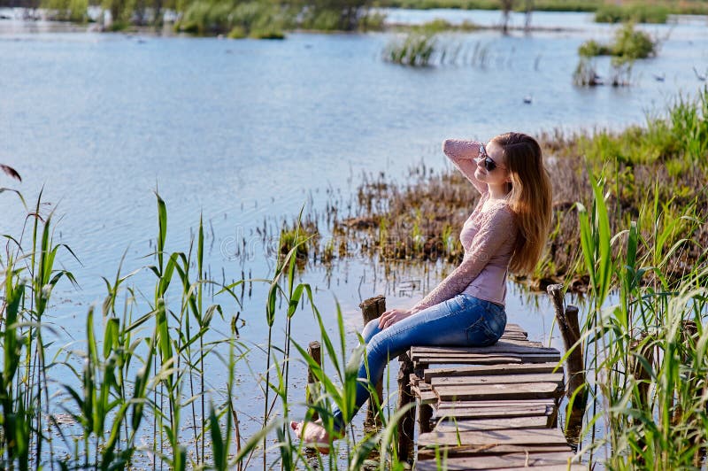 Beautiful Woman Sitting on a Pier at the Lake Stock Photo - Image of ...