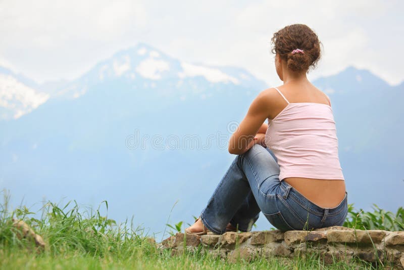Beautiful woman is sitting on a stones royalty free stock photography