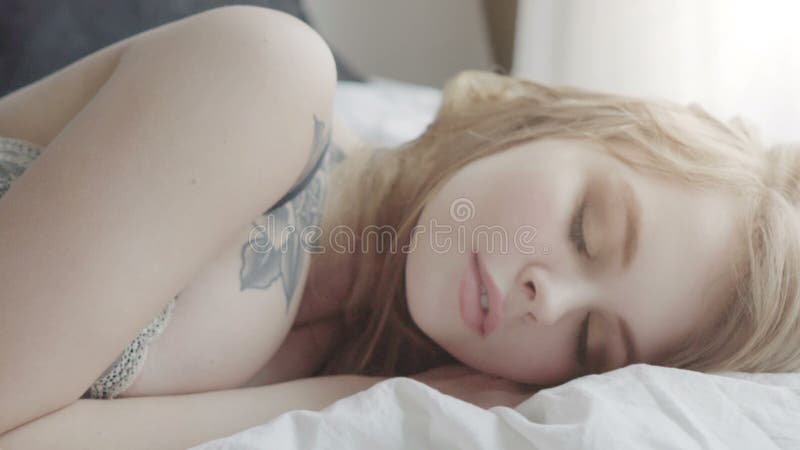 Beautiful woman sleeps in the bedroom, lying on her bed