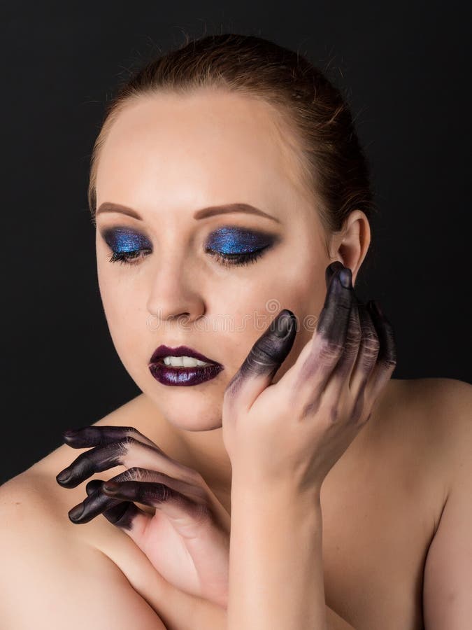 Beautiful Woman With Smoky Eyes Make Up And Finger In The Paint On A