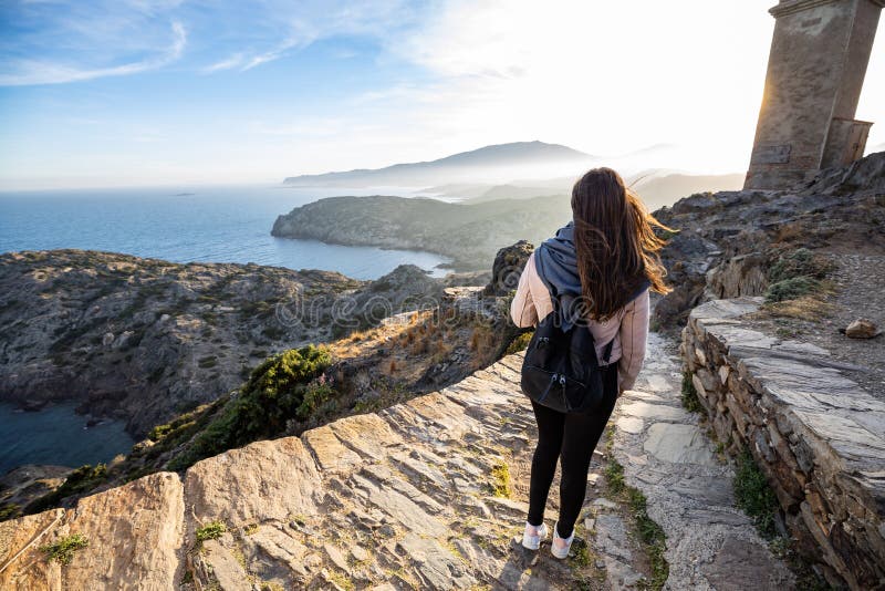 Beautiful woman standing on a cliff during sunset with the mediterranean sea in the background at Cap de Creus royalty free stock image Beautiful woman standing on a cliff during sunset with the mediterranean sea in the background at Cap de Creus royalty free stock image