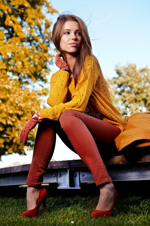 Beautiful woman standing in a park in autumn