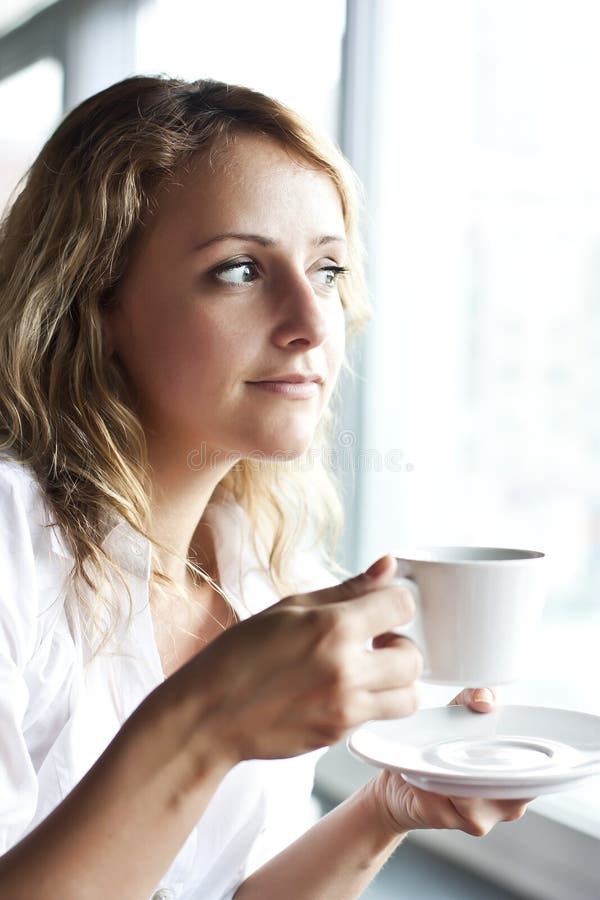 Beautiful woman in street cafe ,with cup