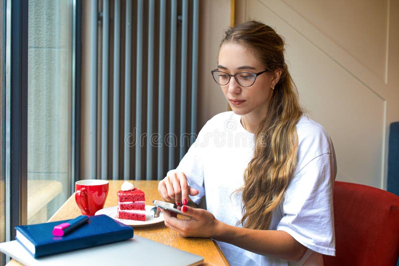 Beautiful woman in trendy glasses checking e-mail on mobile phone