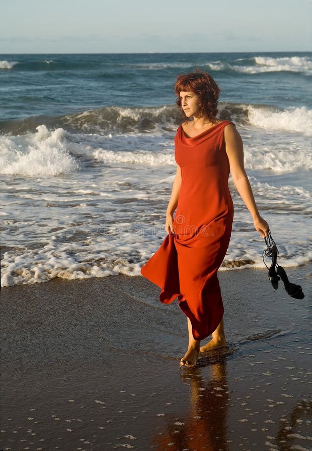 Beautiful woman walking with dress by the seaside