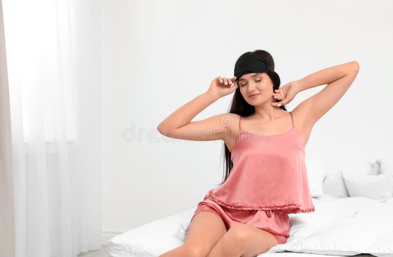 Beautiful woman wearing sleeping mask. Bedtime