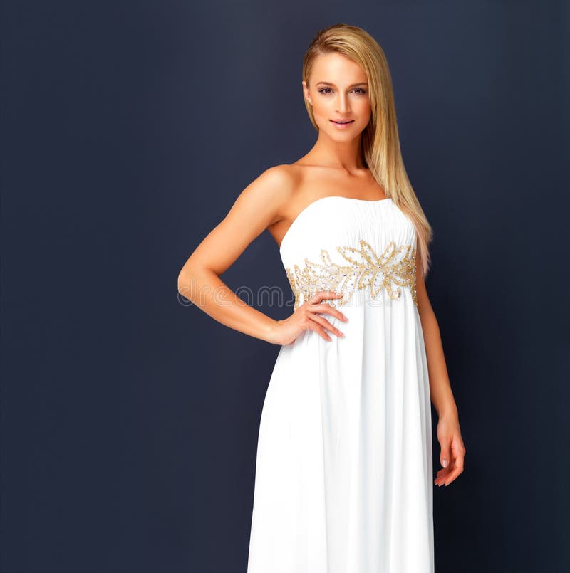 Beautiful woman in a white gala dress and looking gorgeous for prom, orcars or red carpet event. Portrait a fashion and