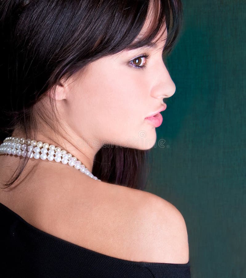 Beautiful woman with white pearl looking back