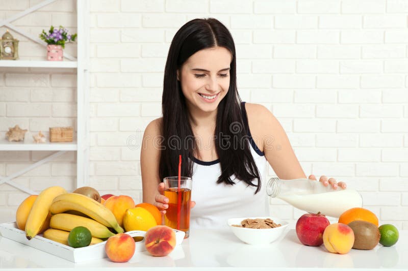 Beautiful women exists with pure skin on her face sitting at a table and eat breakfast. Asian woman eating healthy food at. Banana, caucasian.