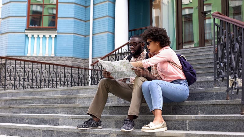 Beautiful woman pointing at map searching direction with boyfriend, travelling