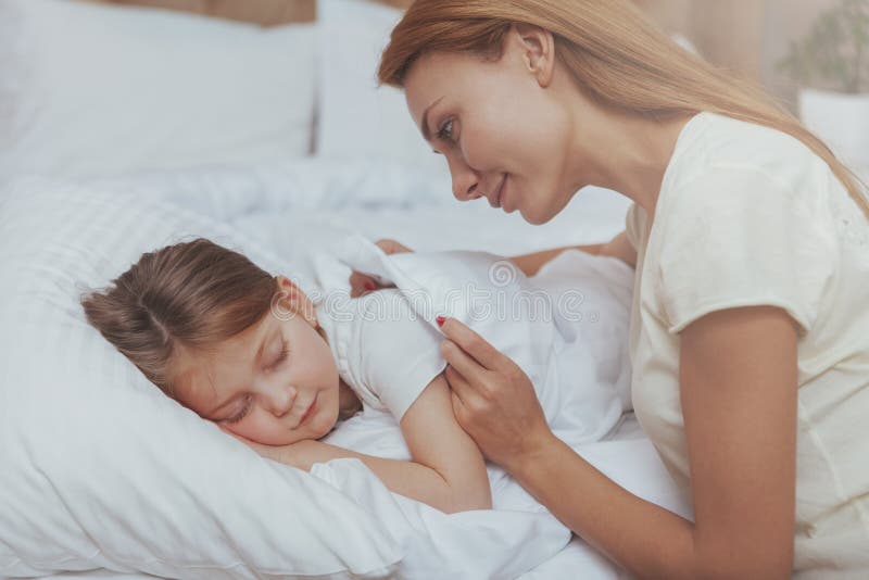 Lovely woman watching her daughter sleeping royalty free stock photography Lovely woman watching her daughter sleeping royalty free stock photography