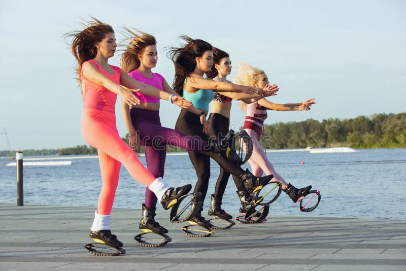 Beautiful Women in Sportswear Jumping in a Kangoo Jumps Shoes at the Street  on Summer`s Sunny Day Stock Image - Image of activity, motion: 189668439