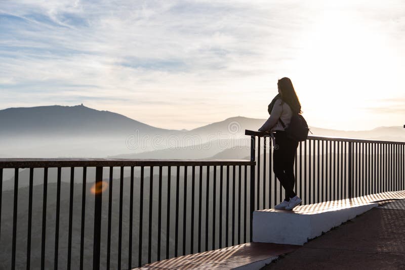 Beautiful women standing at a viewpoint on a cliff during sunset royalty free stock images