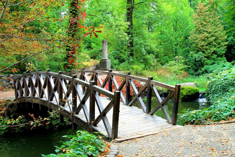 Old Red Wooden Bridge Across Small River in a Green Park. Vintage ...