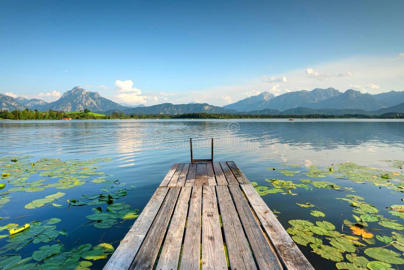 Beautiful wooden jetty on a lake with mountain background royalty free stock images