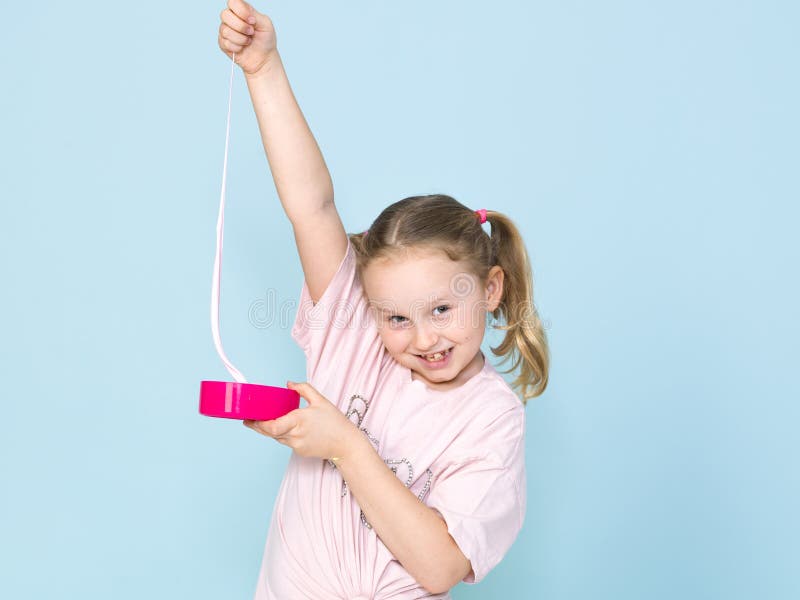 Beautiful 8 year old girl is playing with pink slime in front of blue background stock photos Beautiful 8 year old girl is playing with pink slime in front of blue background stock photos