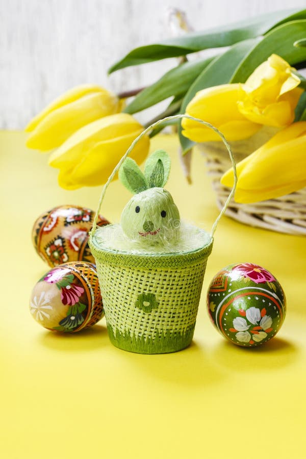 Beautiful yellow tulips in white wicker basket and easter eggs stock images