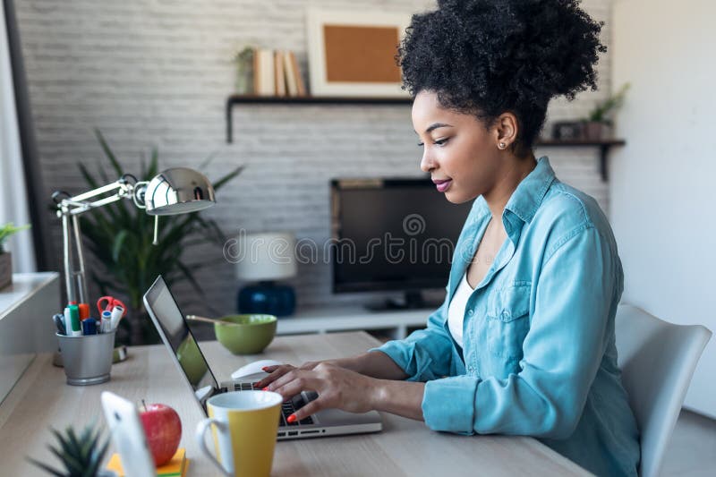 Beautiful young afro business woman working with laptop sitting in the office at home