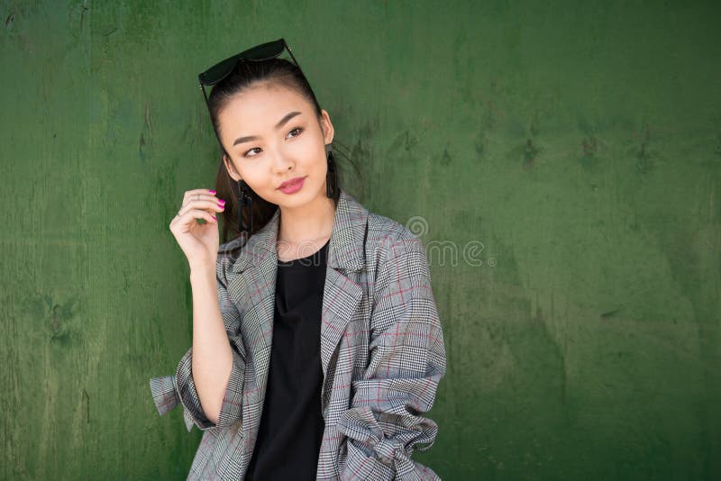 Beautiful young Asian fashion model woman walking on city street wearing jacket and sunglasses. stock photography Beautiful young Asian fashion model woman walking on city street wearing jacket and sunglasses. stock photography