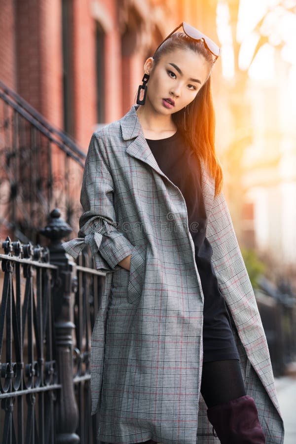 Beautiful young Asian fashion model woman walking on city street wearing jacket and sunglasses. stock photo Beautiful young Asian fashion model woman walking on city street wearing jacket and sunglasses. stock photo