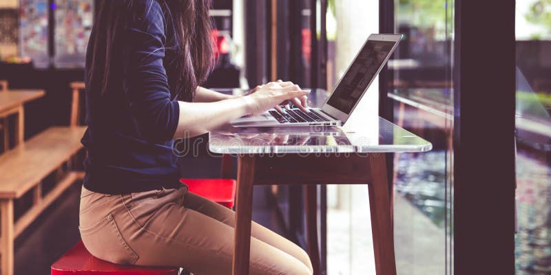 Beautiful young Asian girl working at a coffee shop with a laptop.female royalty free stock image Beautiful young Asian girl working at a coffee shop with a laptop.female royalty free stock image