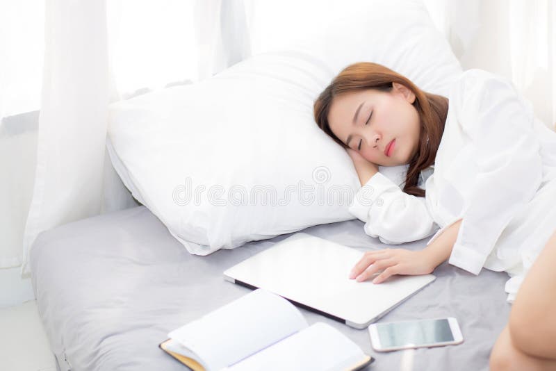 Beautiful young asian woman with laptop lying down in bedroom, girl tired sleep with computer notebook