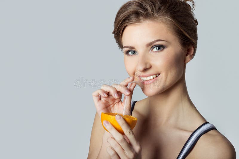 Beautiful young athletic girl energetic happy drinking orange juice, healthy lifestyle royalty free stock image Beautiful young athletic girl energetic happy drinking orange juice, healthy lifestyle royalty free stock image