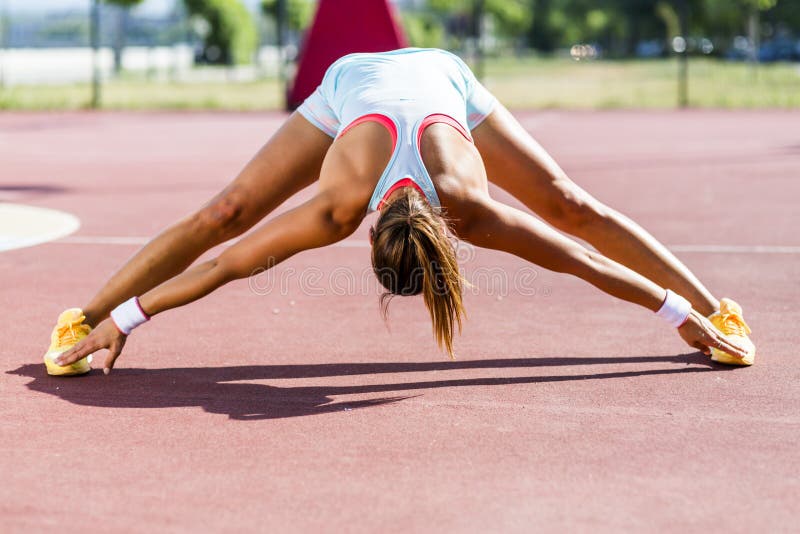 Beautiful young athletic woman stretching in summer stock image