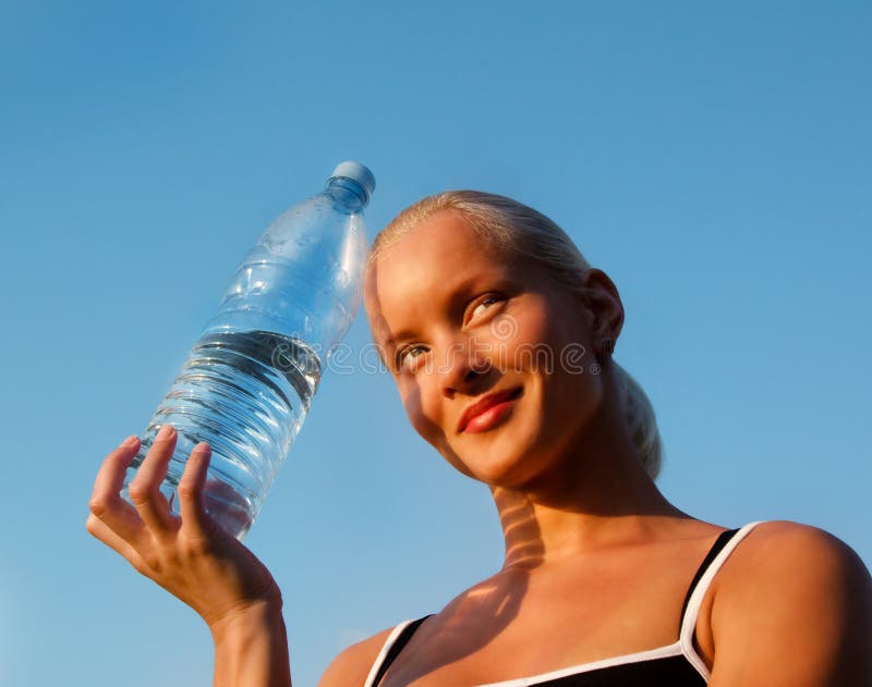 Beautiful young blond girl with bottle of water