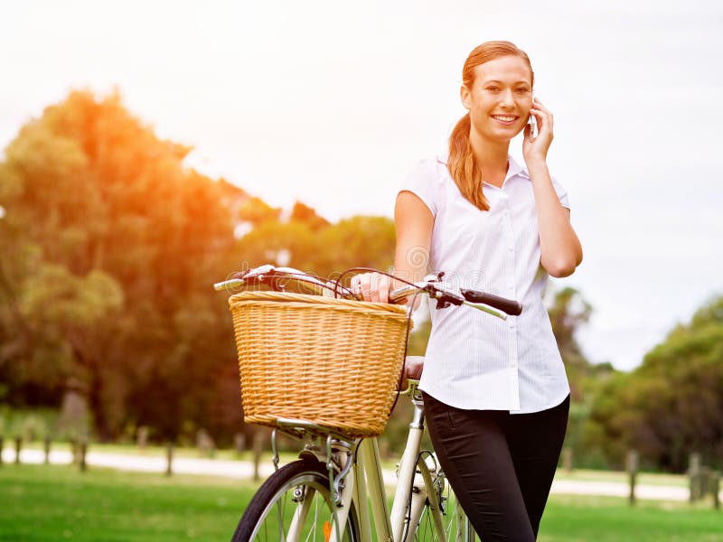 Beautiful young blond woman with bike in park talking over phone royalty free stock images Beautiful young blond woman with bike in park talking over phone royalty free stock images