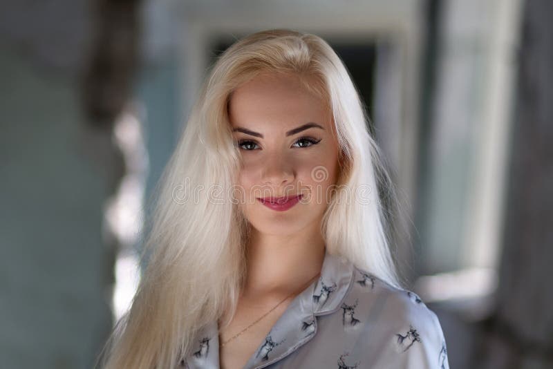 Beautiful young blonde girl with a pretty face and beautiful eyes smiling. Portrait of a woman with long hair and amazing looks. stock photography Beautiful young blonde girl with a pretty face and beautiful eyes smiling. Portrait of a woman with long hair and amazing looks. stock photography