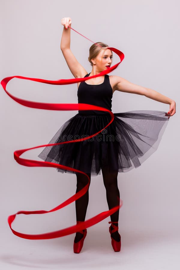 Beautiful young blonde woman ballet gymnast training calilisthenics exercise with red ribbon with red shoes