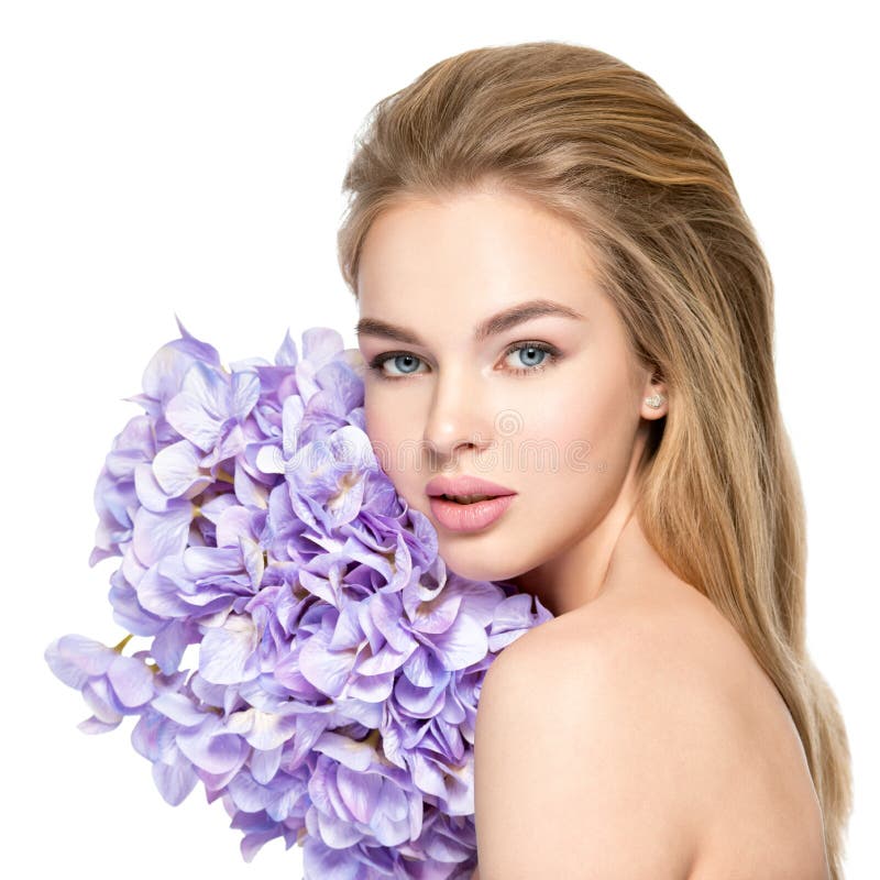 Beautiful young blonde woman with flowers near face