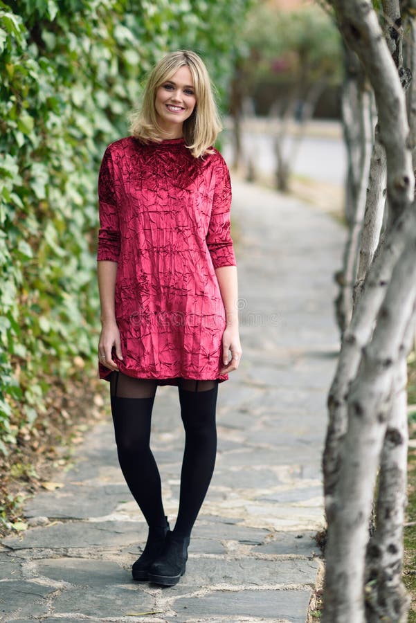 Beautiful young blonde woman smiling in urban background