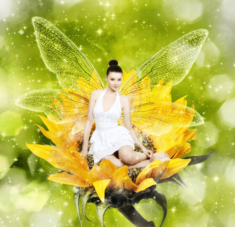 Beautiful young brunette woman as summer fairy on sunflower