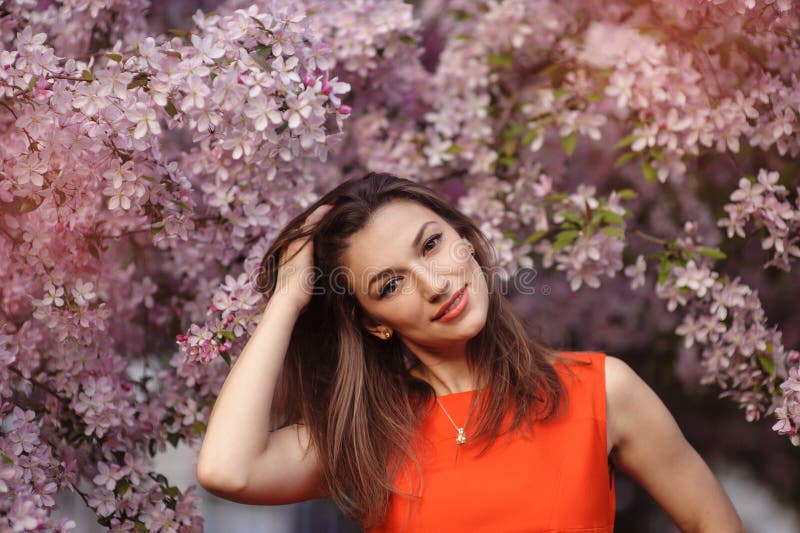 Beautiful young brunette woman on the meadow with white flowers