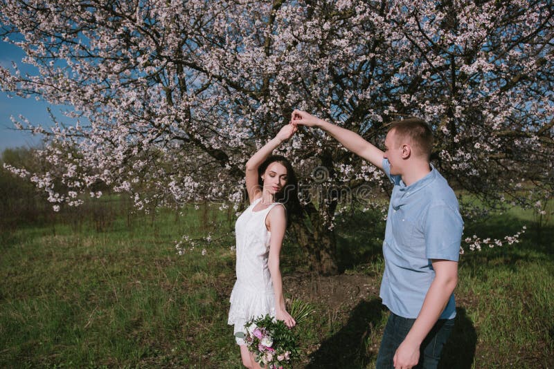 Beautiful young couple dancing and having fun on blue sky background stock photo Beautiful young couple dancing and having fun on blue sky background stock photo