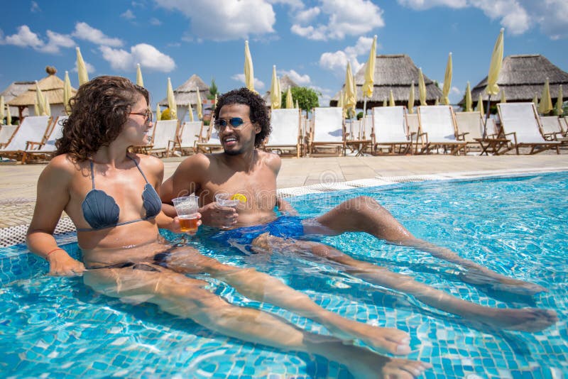 Beautiful young couple enjoying a vacation day at the pool royalty free stock photography Beautiful young couple enjoying a vacation day at the pool royalty free stock photography