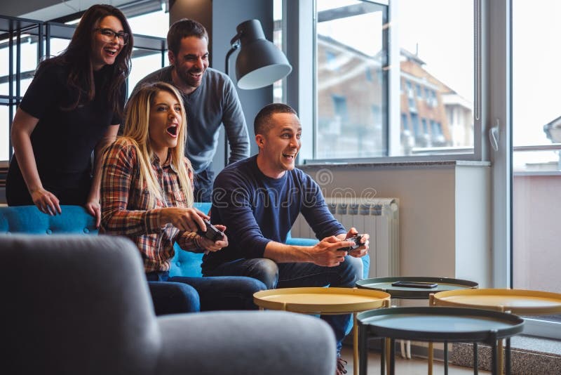 Beautiful young couple playing video games with friends