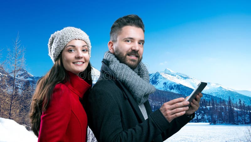 Beautiful young couple in winter clothes in winter mountains