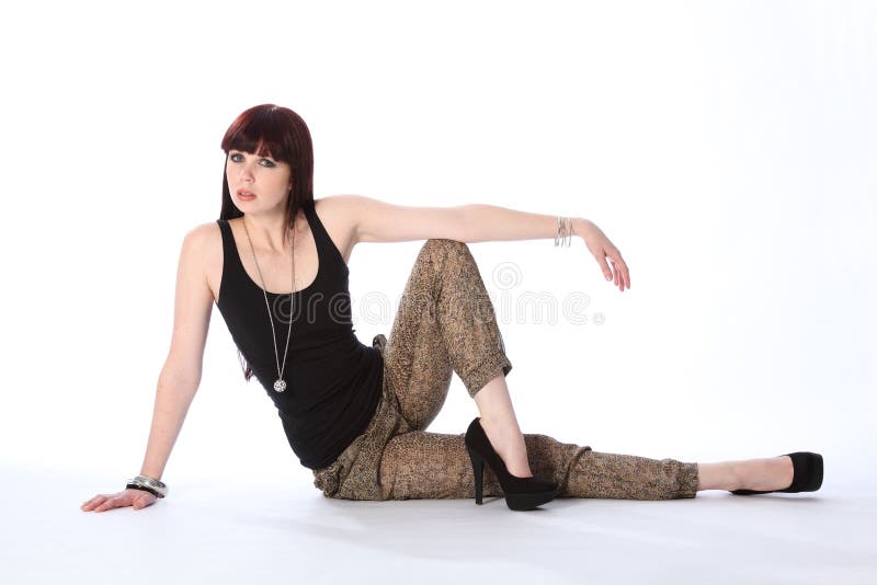 Beautiful young fashion model sitting on floor royalty free stock image