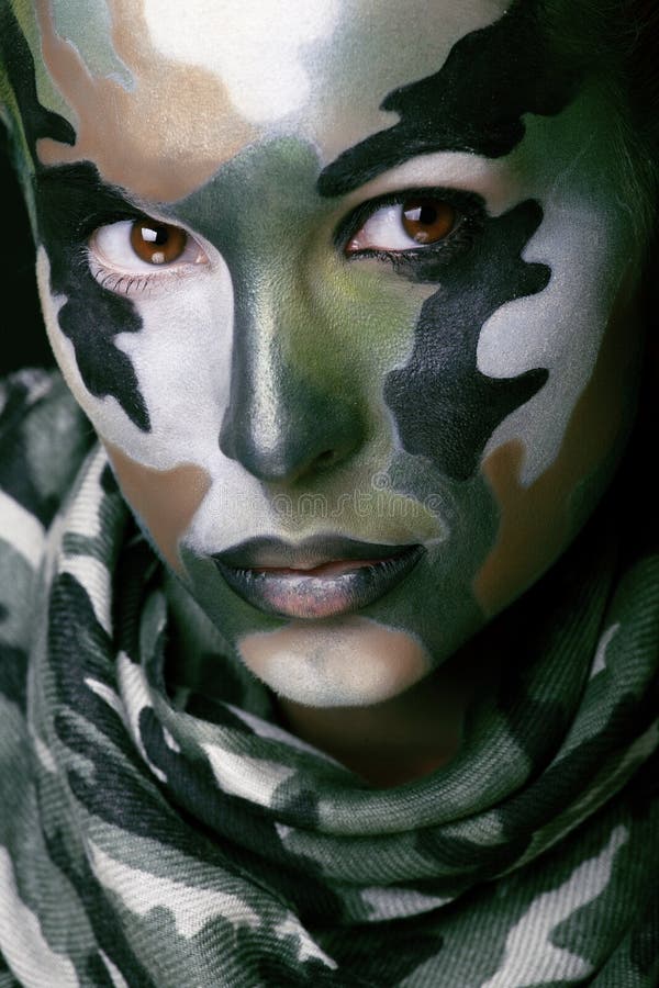 Beautiful young fashion woman with military style clothing and face paint make-up