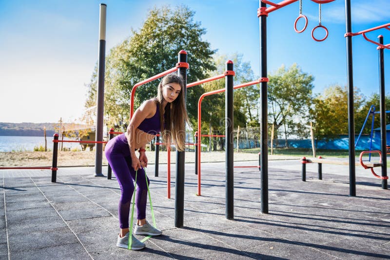 Beautiful Young Female Doing Exercises on the Street of the Playground ...