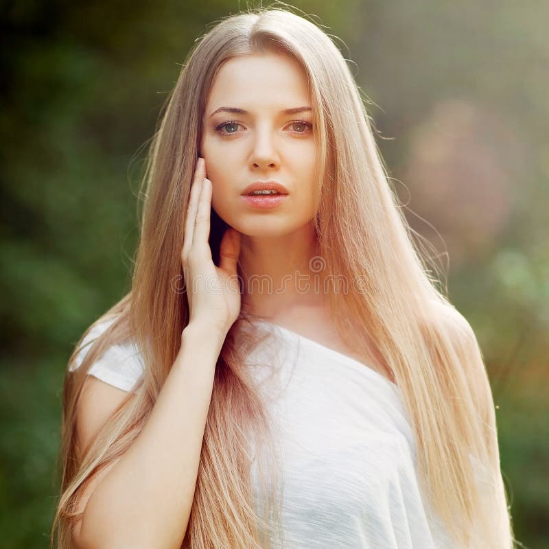 Beautiful young female model with perfect hair touching her skin stock photography Beautiful young female model with perfect hair touching her skin stock photography