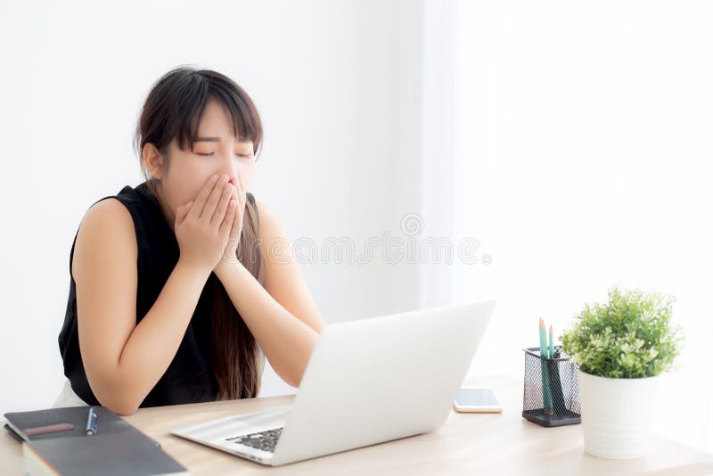 Beautiful young freelance asian woman working bored and tired on laptop computer at the office royalty free stock image Beautiful young freelance asian woman working bored and tired on laptop computer at the office royalty free stock image