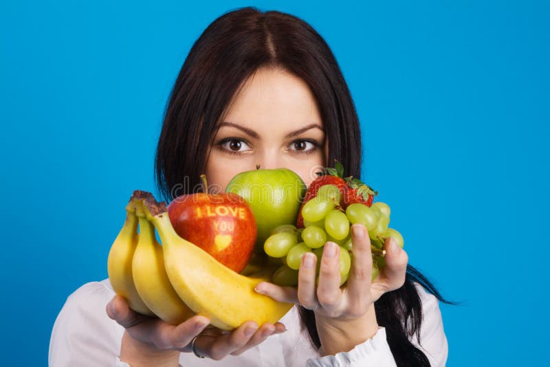 Beautiful young girl with a bunch of fruits