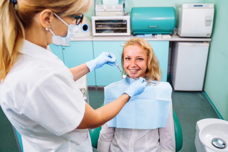 Beautiful young girl at the dentist appointment. An experienced dentist checking the health of patients teeth in a modern dental