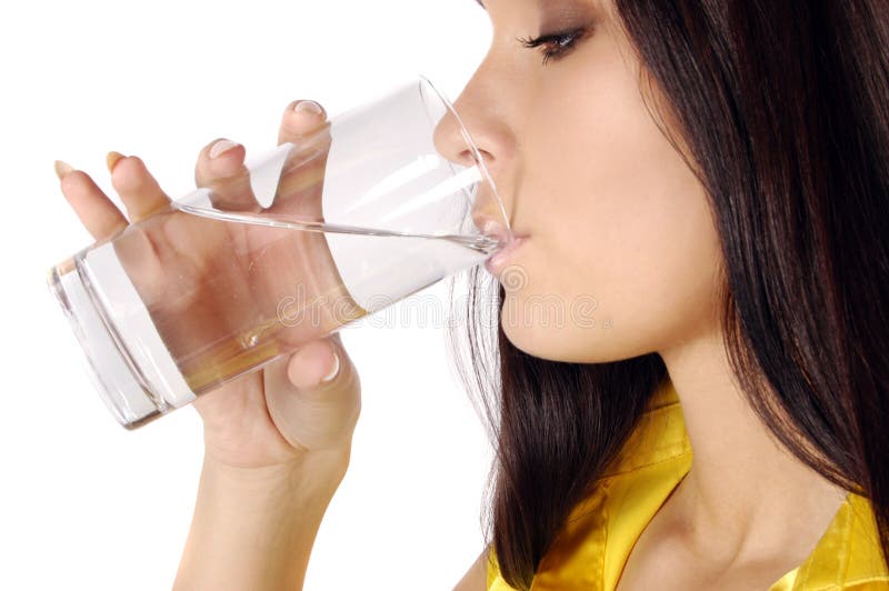 Beautiful young girl drinks water from glass