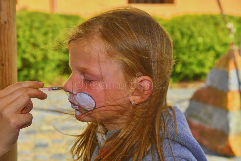 Beautiful young girl with face painted like a rabbit. Face painting on child face stock photos Beautiful young girl with face painted like a rabbit. Face painting on child face stock photos